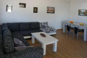 ein Wohnzimmer mit Sofa und Tisch in der Unterkunft Bungalow Thalassa, am Strand und mit Mini-Pool in Kalamaki
