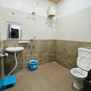 a bathroom with a toilet and a sink at Hotel MI Resort in Panna