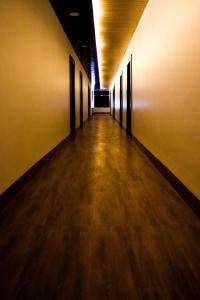 een lege hal met zwarte deuren en een houten vloer bij Hotel MI Resort in Panna
