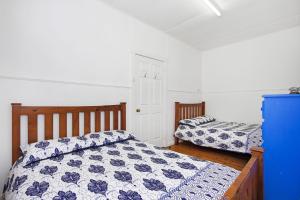 1 Schlafzimmer mit 2 Betten und einem blauen Schrank in der Unterkunft The Butterfly House in Bendalong in Manyana