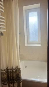 bagno con vasca e finestra di Готель Колиба Колорит a Tatariv