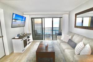 a living room with a couch and a tv at Ocean Breeze Condo in Jensen Beach