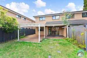 a brick house with a patio and a fence at Aircabin - Carlingford - Sydney - 4 Beds House in Sydney