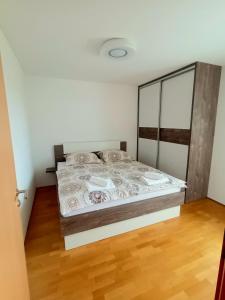 een bed in een kamer met een houten vloer bij Hakuna Matata in Moravske-Toplice