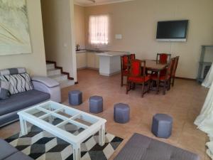 uma sala de estar com um sofá e uma mesa em The Villa em Bulawayo