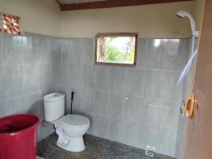 a bathroom with a toilet and a window at Bugo Camp Glamping & Natural Activity in Munduk