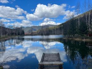 a lake with a wooden dock in the middle at Готель Колиба Колорит in Tatariv