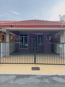 a purple house with a fence in front of it at Homestay Pusat Bandar Kangar in Kangar