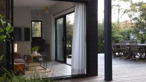 a screened in porch with a sliding glass door at The Getaway in Manyana