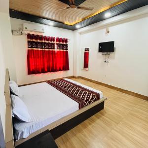 a bedroom with a bed and a tv on the wall at Hotel MI Resort in Panna