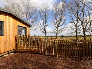 a wooden fence in front of a house at Ash Lodge in Morpeth