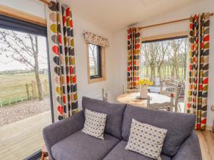 a living room with a couch and a patio at Ash Lodge in Morpeth