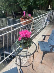 un tavolo di vetro con fiori rosa sopra di Dana house a Napoli