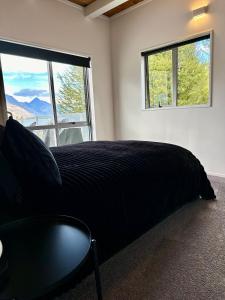a bedroom with a large bed and a window at Te Wai • Luxe @ The Lake • in Queenstown