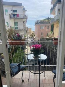 un tavolo con un vaso di fiori sul balcone di Dana house a Napoli