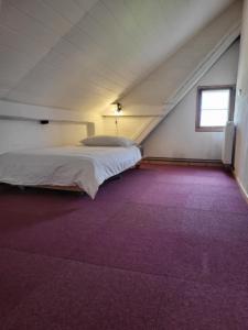 Cama en habitación con alfombra morada en Alte Schule Brodowin, en Chorin