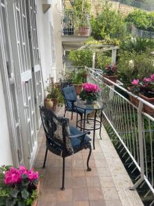 a balcony with chairs and a table and flowers at Dana house in Naples