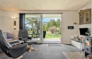 een woonkamer met een bank en stoelen en een glazen schuifdeur bij Beautiful Home In Frvang With Sauna in Fårvang