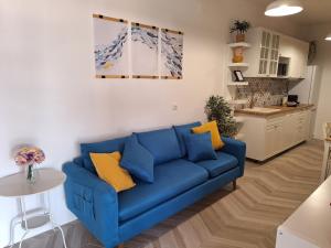 a blue couch in a living room with a kitchen at Blue Promenade Apartments in Dubrovnik