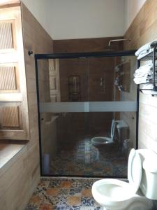 łazienka z przeszkloną kabiną prysznicową i 2 toaletami w obiekcie Hotel Hacienda Maravillas w mieście Nopala