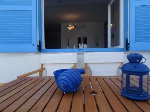 un vase bleu assis au-dessus d'une terrasse en bois dans l'établissement Splendid Santorini Villa | Bella Beach House | 3 Bedrooms | Private Terrace and Beautiful Sea Views | Monolithos, à Monolithos