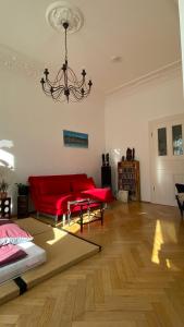 a living room with a red couch and a chandelier at Schönes Jugendstil Appartement in bester Lage in Leipzig