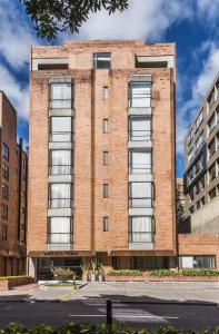 a brick building with many windows on a street at Travelers Fontana Plaza in Bogotá