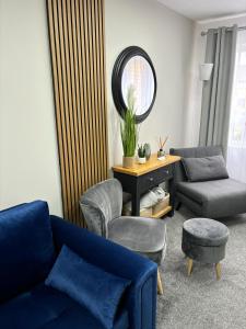 リンリスゴーにあるStylish home in Linlithgowのリビングルーム(青いソファ、椅子、鏡付)