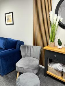 ein Wohnzimmer mit einem Stuhl und einem blauen Sofa in der Unterkunft Stylish home in Linlithgow in Linlithgow