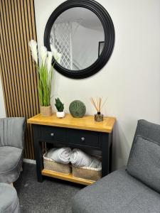 einen Spiegel an einer Wand über einem Tisch mit einem Stuhl in der Unterkunft Stylish home in Linlithgow in Linlithgow