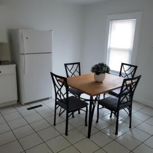 a kitchen with a table and chairs and a refrigerator at Entire 4 bedroom house - Enfield in Enfield