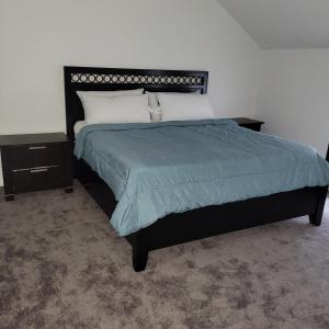 a bedroom with a large bed with a blue comforter at Entire 4 bedroom house - Enfield in Enfield