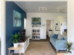 uma sala de estar com paredes azuis e um sofá azul em Yonder Cottage em Manyana