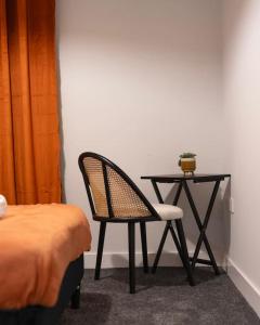 a desk with a chair and a table with a plant on it at TQ luxurious 2 bed flat in Birmingham