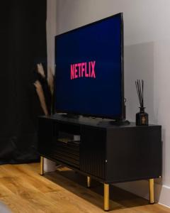 a television on a tv stand with a netflix at TQ luxurious 2 bed flat in Birmingham