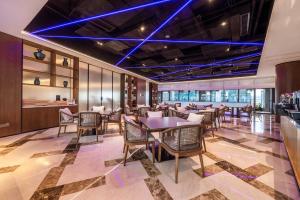 un comedor con mesas, sillas y luces azules en SSAW Hotel Chongqing Great World Jiefangbei en Chongqing