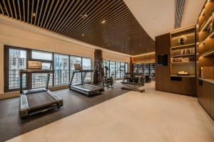 a gym with several treadmills and cardio machines at SSAW Hotel Chongqing Great World Jiefangbei in Chongqing