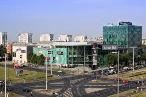 a city with a large green building and a parking lot at Cosy and elegant flat with spectacular city view in Zagreb