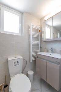 a white bathroom with a toilet and a sink at Marina Zeas Skydeck in Piraeus