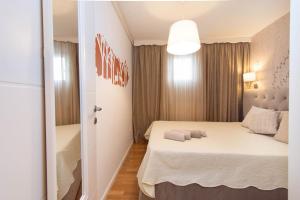 um pequeno quarto com uma cama num quarto em Cosy and elegant flat with spectacular city view em Zagreb