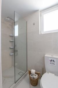 a bathroom with a glass shower with a toilet at Marina Zeas Skydeck in Piraeus