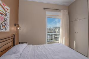 a bedroom with a bed and a window at Marina Zeas Skydeck in Piraeus