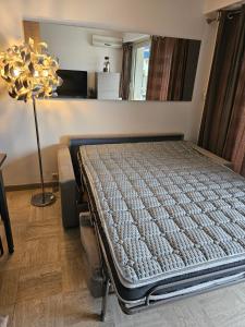 Bett in einem Zimmer mit Lampe in der Unterkunft Superbe vue mer à 50 mètres des plages in Cannes