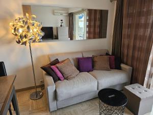 ein Wohnzimmer mit einem Sofa und bunten Kissen in der Unterkunft Superbe vue mer à 50 mètres des plages in Cannes