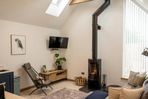 a living room with a wood stove in the corner at Nana Cottage , Findhorn Village in Findhorn