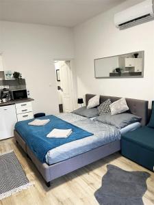 a bedroom with a bed and a couch at Bereg Szíve Apartman in Vásárosnamény
