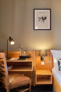 a bedroom with a desk and a bed with a lamp at Hotel Roter Hahn in Regensburg