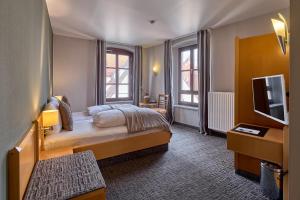 pokój hotelowy z łóżkiem i telewizorem w obiekcie Hotel Roter Hahn w Ratyzbonie