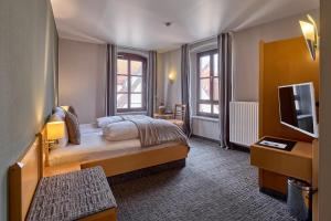 a hotel room with a bed and a television at Hotel Roter Hahn in Regensburg