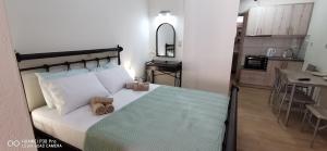 a bedroom with a large bed and a kitchen at Η Αρμενόπετρα in Gerolimenas